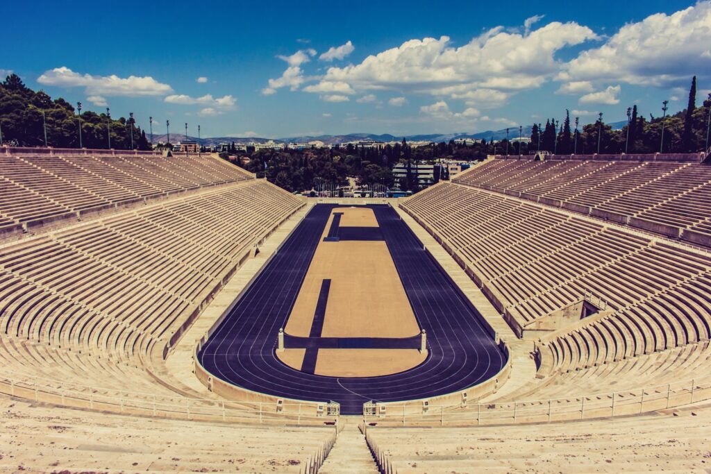 The marble horseshoe of the Panathenaic Stadium in Athens, pale stone tiers rising around the dark running track